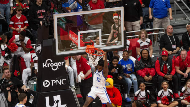 Kentucky's Antonio Reeves (12) dunked a lob from Reed Sheppard (15) as the Louisville Cardinals and the Kentucky Wildcats faced off in their annual rivalry matchup at the KFC Yum Center in downtown Louisville on Thursday, Dec. 21, 2023.